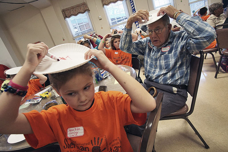 General News - HM - Isabella Blevins (left) a 3rd grader at Sherman Elementary, and R.C. Pittenger attempt to draw a Christmas Tree during the ninth annual Christmas party at Dayspring Assisted Living. (Mitchell Pe Masilun / The (Mansfield) News Journal)