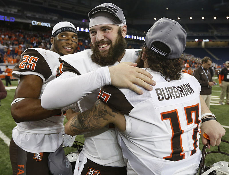    Sports Feature - HM - Bowling Green State University players Nilijah Ballew (25) Matt Johnson (11) and Ryan Burbrink (17) celebrate after defeating Northern Illinois University 34-14 to win the MAC football championship game at Ford Field in Detroit. (Andy Morrison / The (Toledo) Blade)