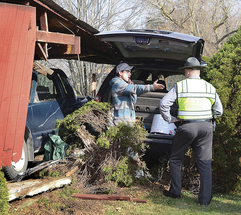 Spot News - 2nd place - Clint Eisnnicher talks with a highway patrol Sgt. Ron Cox after his vehicle plowed through a carport at a home on state Route 517 in Fairfield Township.  (Patricia Schaeffer / The (Lisbon) Morning Journal)