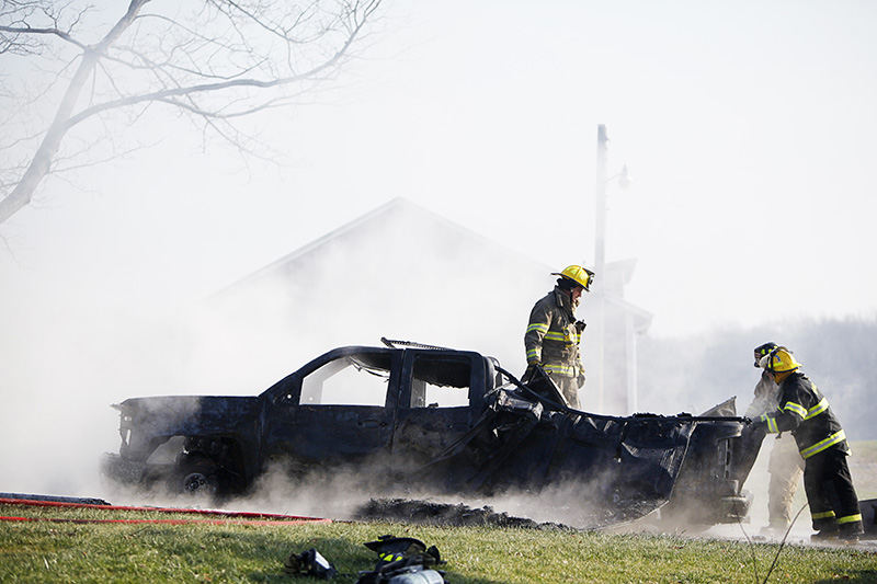 Spot News - HM - Firemen check out a truck that was the cause of a house fire on Collins Road in Berlin Heights after pulling it from the smoldering garage. (Angela Wilhelm / Sandusky Register)