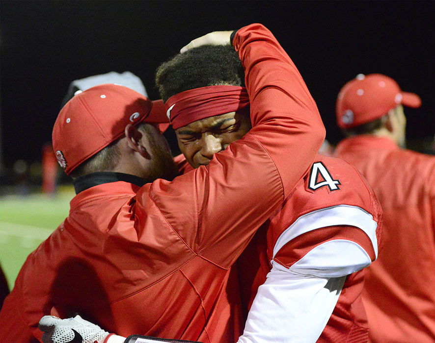 Sports Feature - 3rd place - Port Clinton's Donte McClure is consoled after losing 44-7 to Bishop Hartley. (Molly Corfman / The News-Messenger)