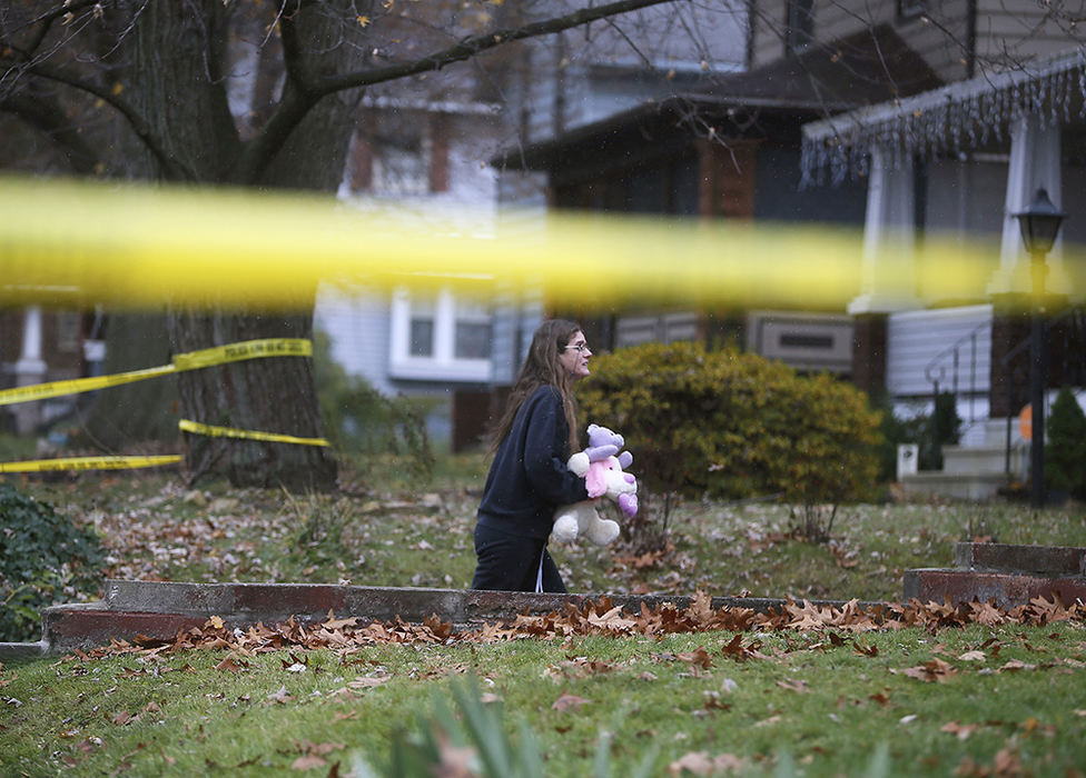 Spot News - 1st place - Lisa Sine, a neighbor to the family of four who passed away in a house fire at 266 E Tallmadge Ave. in Akron walks up the path of to the home to place stuffed animals for the two young girls who died. "They were a very good family," she said as tears ran down her face. (Leah Klafczynski / Akron Beacon Journal)