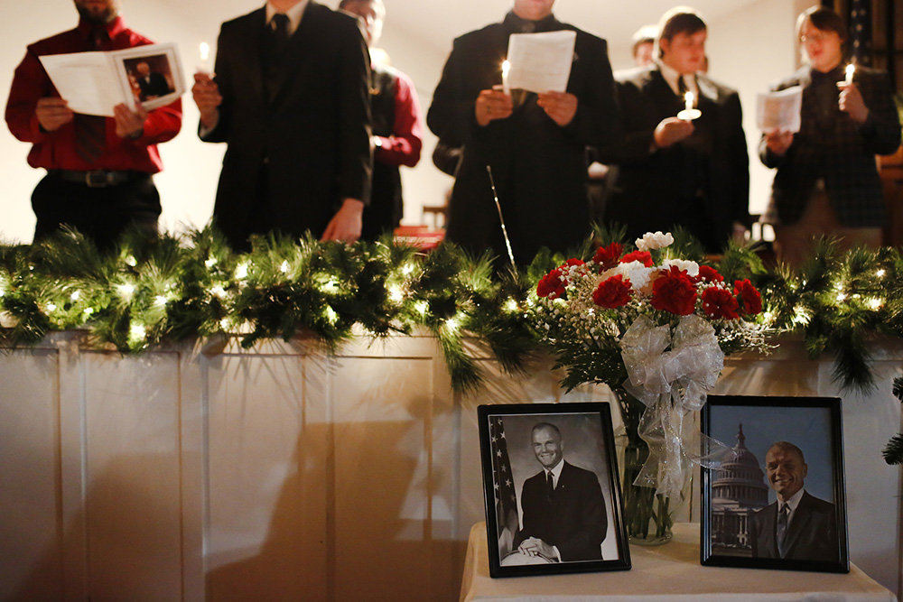 MTStory - 3rd place - Portraits of native son John Glenn sit on a table as members of the Phi Mu Alpha Sinfonia at Muskingum University sing during a memorial service commemorating Glenn's life at Westminster Presbyterian Church in New Concord, Ohio. Glenn, a native of New Concord, was the first man to orbit the Earth and later served as a U.S. Senator from Ohio. (Joshua A. Bickel / The Columbus Dispatch)