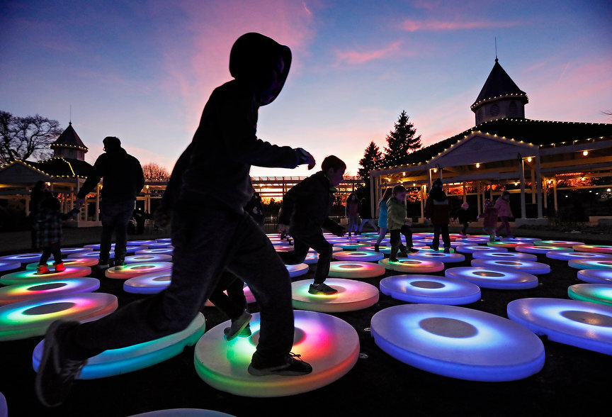 Feature - 3rd place - Children hop from one disc to another in the installation The Pool by artist Jen Lewin.The display of interactive pads of shifting and fading colors will be at Franklin Park Conservatory through January 4.(Eric Albrecht / The Columbus Dispatch)