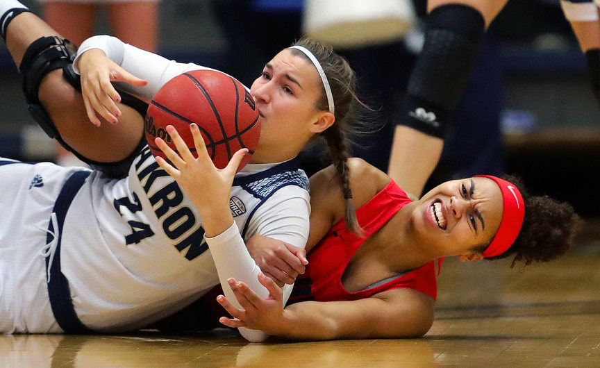 Sports - HM - Akron Zips forward Vari Caitlin (left) takes to the floor to fight for a loose ball against Duquesne guard Nina Aho during the first half of a game in Akron.(Jeff Lange / Akron Beacon Journal)