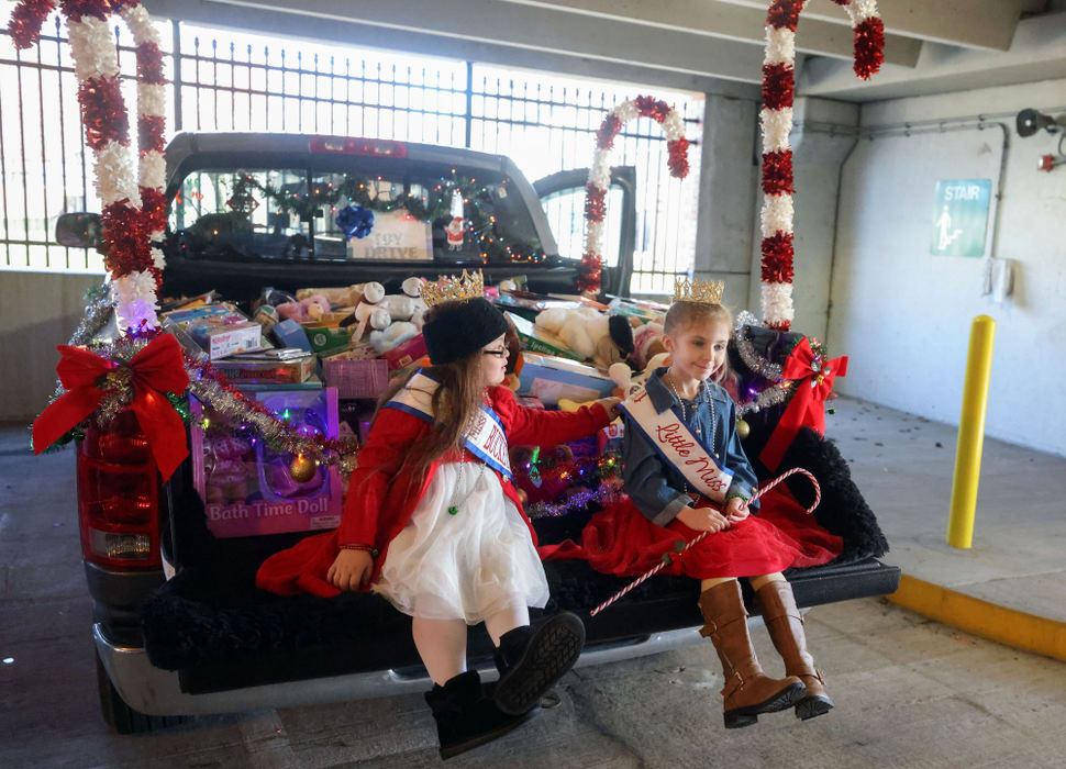 Feature - HM - Little Miss Buckeye State Kallie Lewis, 7, (left) adjusts the sash of Little Miss Ohio Addison King, 8, as they get ready in a Mercy Health St. Vincent Medical Center parking garage to deliver the toys at Mercy Children’s Hospital in Toledo. The two young pageant titleholders, both from Toledo, held a toy drive for kids at the hospital culminating in the delivery of over 700 toys. (Kurt Steiss / The Blade) 