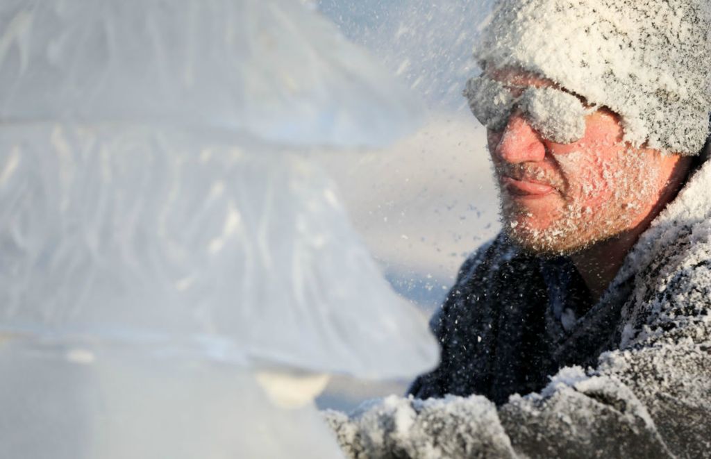 General News - 3rd place - Matthew Larsen, of Napoleon-based Ice Creations, gets covered in ice as he carves a Christmas tree during the city tree lighting event at Ottawa Park in Toledo. (Kurt Steiss / The Blade) 