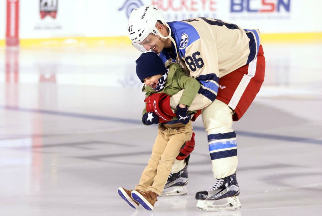 Sports Feature - 2nd place - Former Toledo Walleye player Evan Rankin skates around the Winterfest ice rink with his son, Nash, 3, after a game between the Toledo hockey alumni and the Detroit Red Wings alumni at Fifth Third Field in Toledo. The Toledo team combined alumni from Toledo hockey teams through the years, which included the Goaldiggers, Storm and Walleye. (Kurt Steiss / The Blade) 