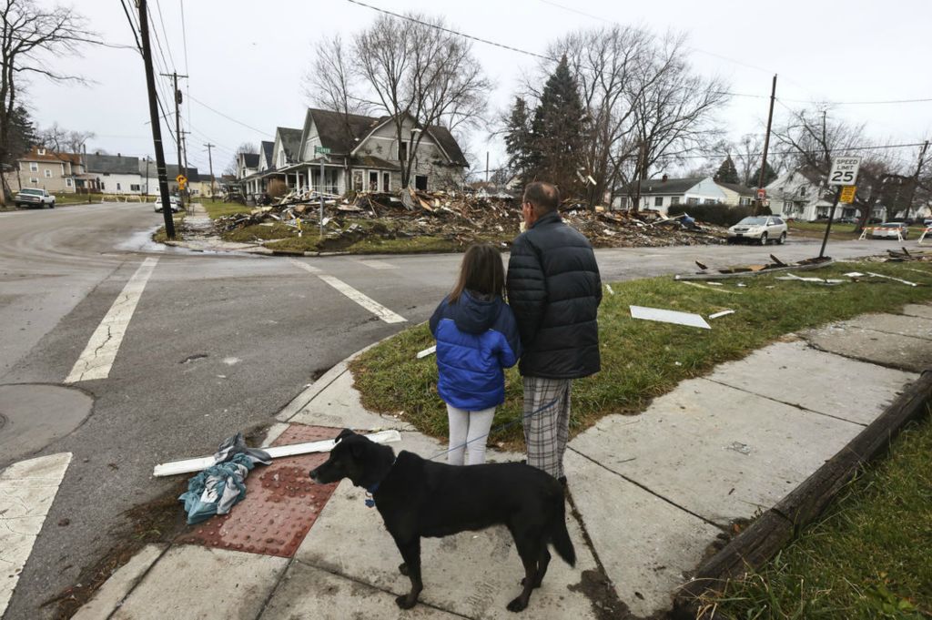 Spot News - 1st place - Mark Yglesias and his daughter McKenzie, 9, walk their dog Sheba past a home at the intersection of Western Avenue and Eldred Avenue that exploded in Toledo. Mr. Yglesias said the explosion shook his nearby home. (Jeremy Wadsworth / The Blade) 