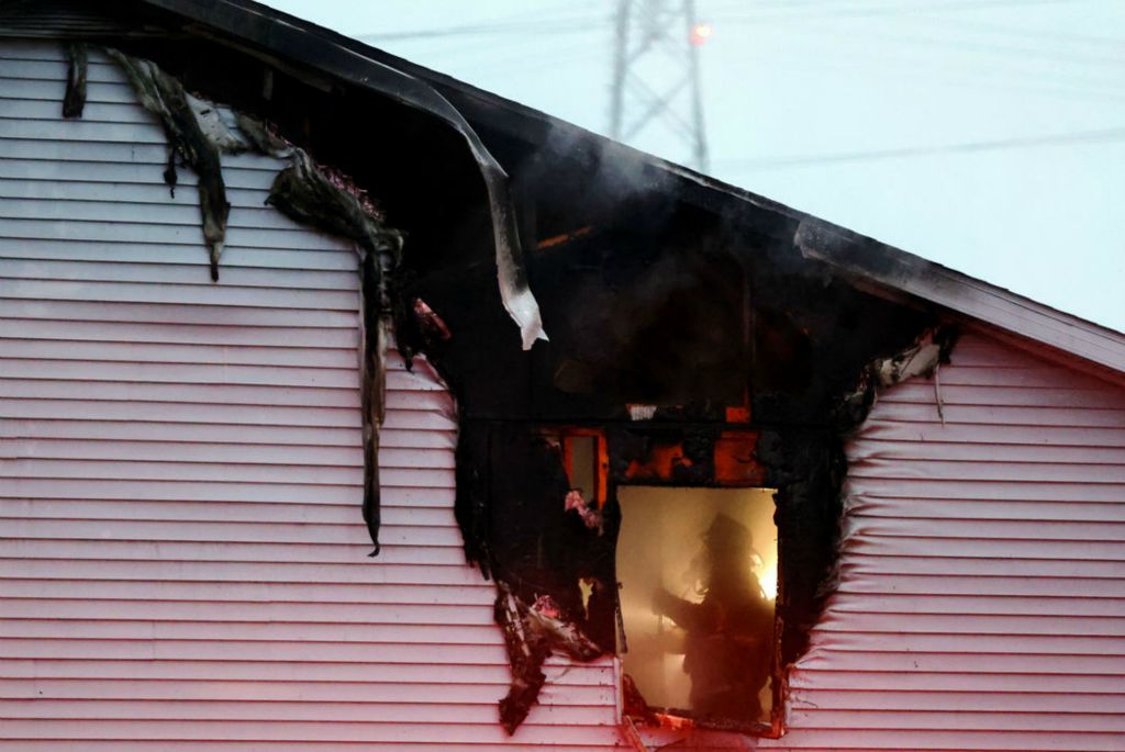 Spot News - 3rd place - A firefighter is seen through a window on a burnt section of the apartment while working on the scene of a fire at the Regina Manor Apartments in Toledo. No occupant injuries were reported and all those inside were either able to get out on their own or were evacuated by firefighters, according to Toledo Fire and Rescue spokesman Pvt. Sterling Rahe. There was one minor firefighter injury reported.  (Kurt Steiss / The Blade) 