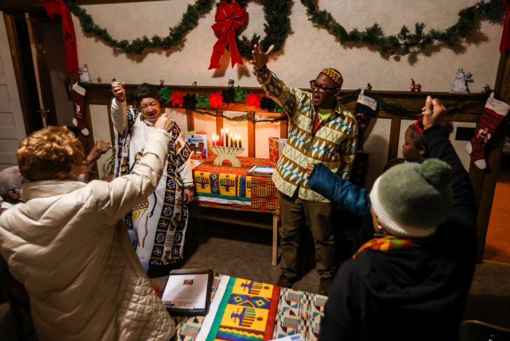 Feature - 3rd place - Toledo resident Diane Gordon (left) and Brother Washington Muhammad close out a Kwanzaa celebration at the Padua Center located in the Kwanzaa Park Neighborhood in Toledo.  (Isaac Ritchey / The Blade)