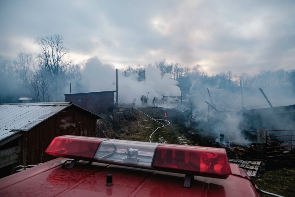 Spot News - 1st place - Firefighters work on extinguishing the remnants of a barn fire on the Keeton farm at 15639 Grove Rd. SE, in Perry Township. (Andrew Dolph / The Times Reporter)