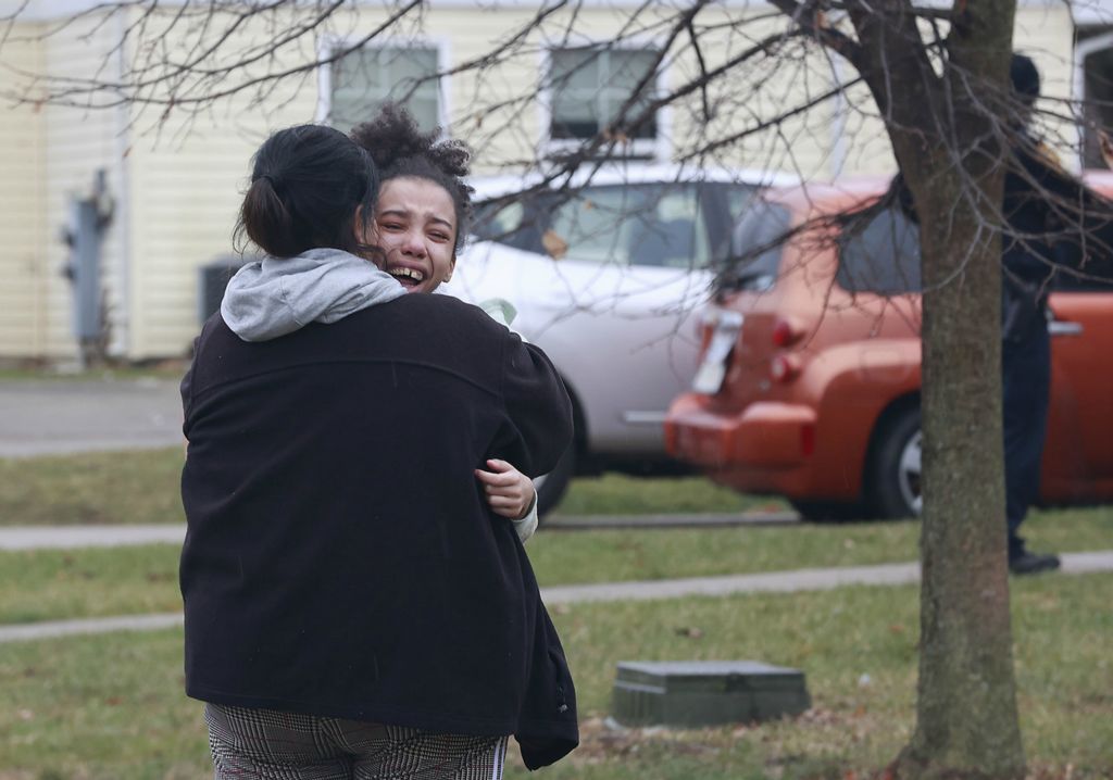 Spot News - 2nd place - A girl is consoled as she cries in front of her house on Lincoln Park South after a man, who was shot, burst into her house and asked for help.  (Bill Lackey / Springfield News-Sun)