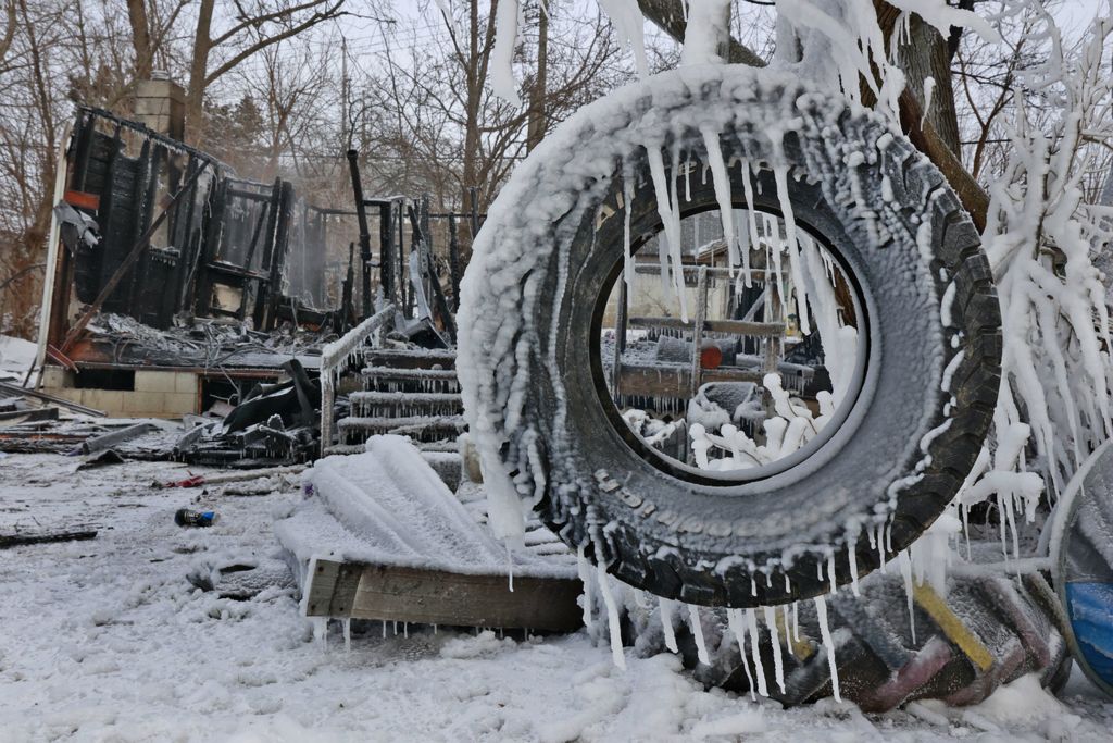 Spot News - 3rd place - A tire swing is coated in ice in front of the smoldering remains of a house in the 300 block of Lyle Avenue in Springfield Township.  (Bill Lackey / Springfield News-Sun)