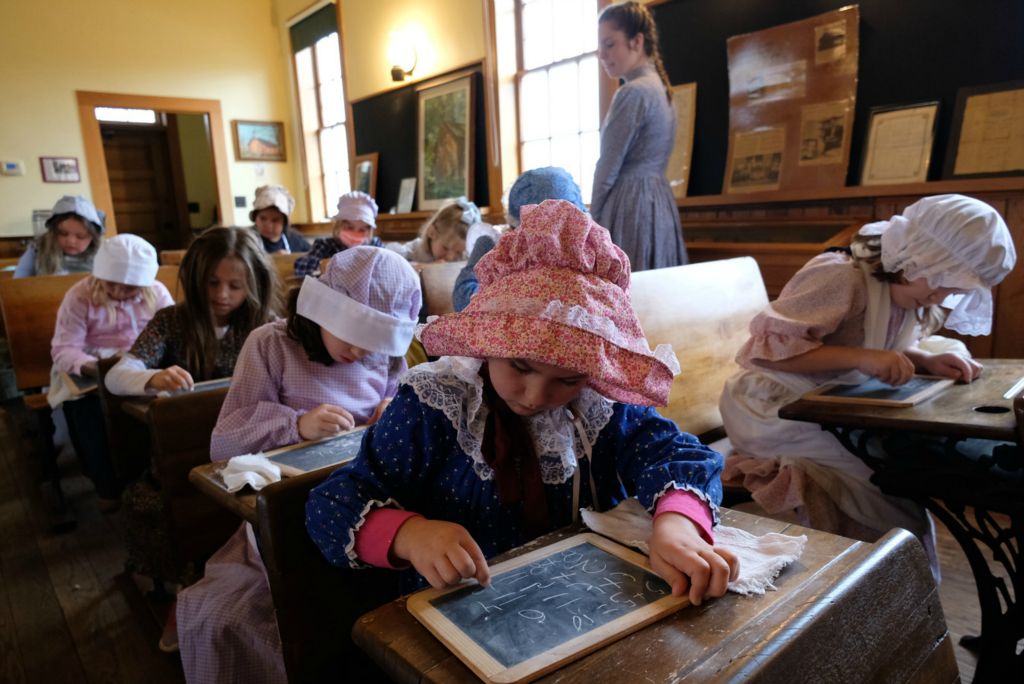 Story - 1st place - Crim Elementary second graders walked to the Little Red Schoolhouse on the campus of Bowling Green State University to go back more than 100 years in time and learn what it was like to attend a one-room school. The schoolhouse was moved to its current site on the Bowling Green State University campus from Huron County in 1976. (J.D. Pooley / Sentinel-Tribune )