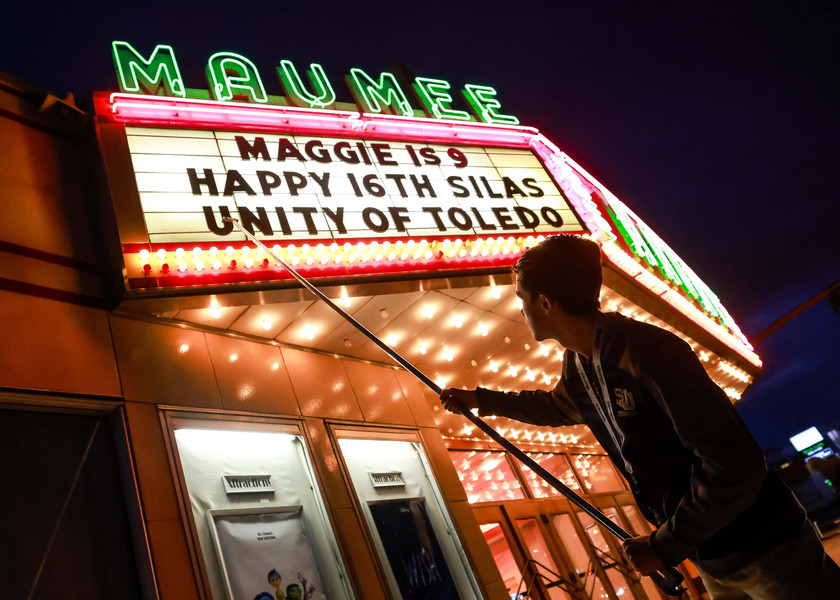 Feature - 2nd place - Toledo resident Charlie Seewer, a senior at St John's Jesuit High School, changes the letters displayed on the marquee outside the Maumee Indoor Theater in Maumee. (Isaac Ritchey / The Blade)