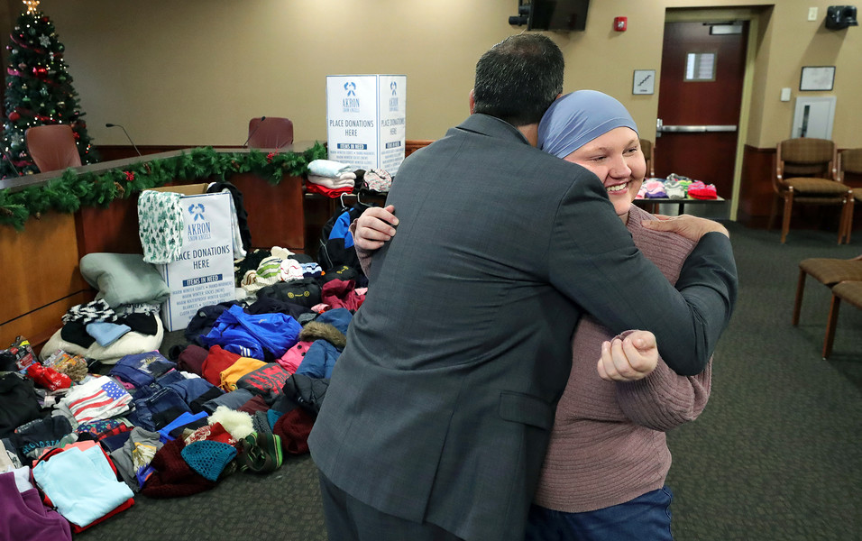 General News - 2nd place - Bella Rink, 18, hugs Green Mayor Rocco Yeargin after being presented with clothing donations collected by city employees in Green. Rink, who was diagnosed with Hodgkin’s lymphoma, ordinarily collects donations for Akron Snow Angels herself but her diagnosis and treatments prevented her from doing so this year. (Jeff Lange / Akron Beacon Journal)