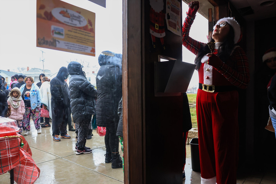 General News - 3rd place - Linda Parra opens the doors as people wait in line for the seventh annual Feliz Navidad at Nuestra Gente Community Center in Toledo. (Rebecca Benson / The Blade)