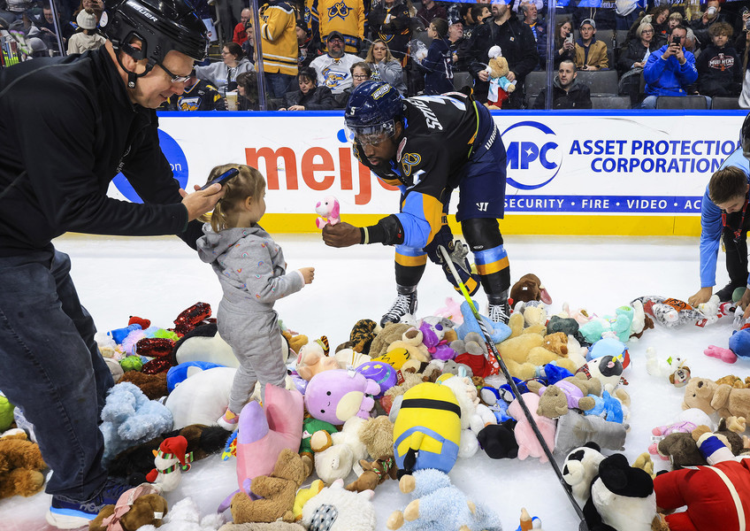 Sports Feature - 2nd place - Toledo’s Jalen Smereck offers a stuffed animal to a little girl while helping clean up the Teddy Bear Toss in the second period of an ECHL hockey game at the Huntington Center in Toledo. (Rebecca Benson / The Blade)