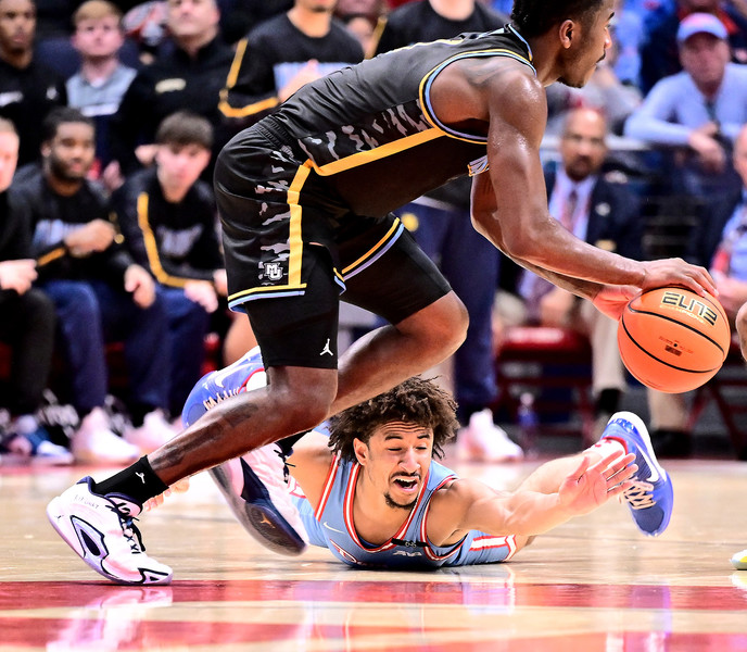 Sports - HM - Dayton's Javon Bennet dives on the floor trying to steal the ball from the Marquette's Kam Jones during the 2nd half of action at UD Arena. Dayton defeated Marquette 71 - 63. (Erik Schelkun / Elsestar Images)