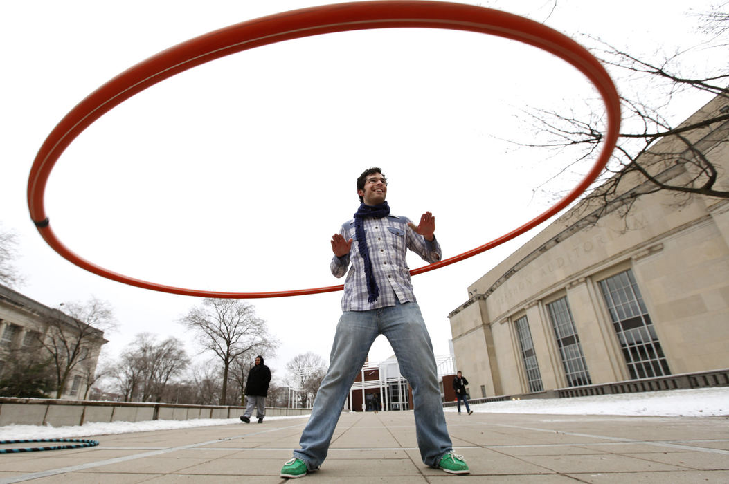 Feature - 3rd place - OSU student Yuri Broze, of St. Louis was playing with a large hula hoop on the plaza at the Wexner Center. Broze is a music major studying "Cognitive and Systematic Musicology".  He was encouraging passers by to try out the six-foot-diameter hoop.  (Jeff Hinckley / The Columbus Dispatch)