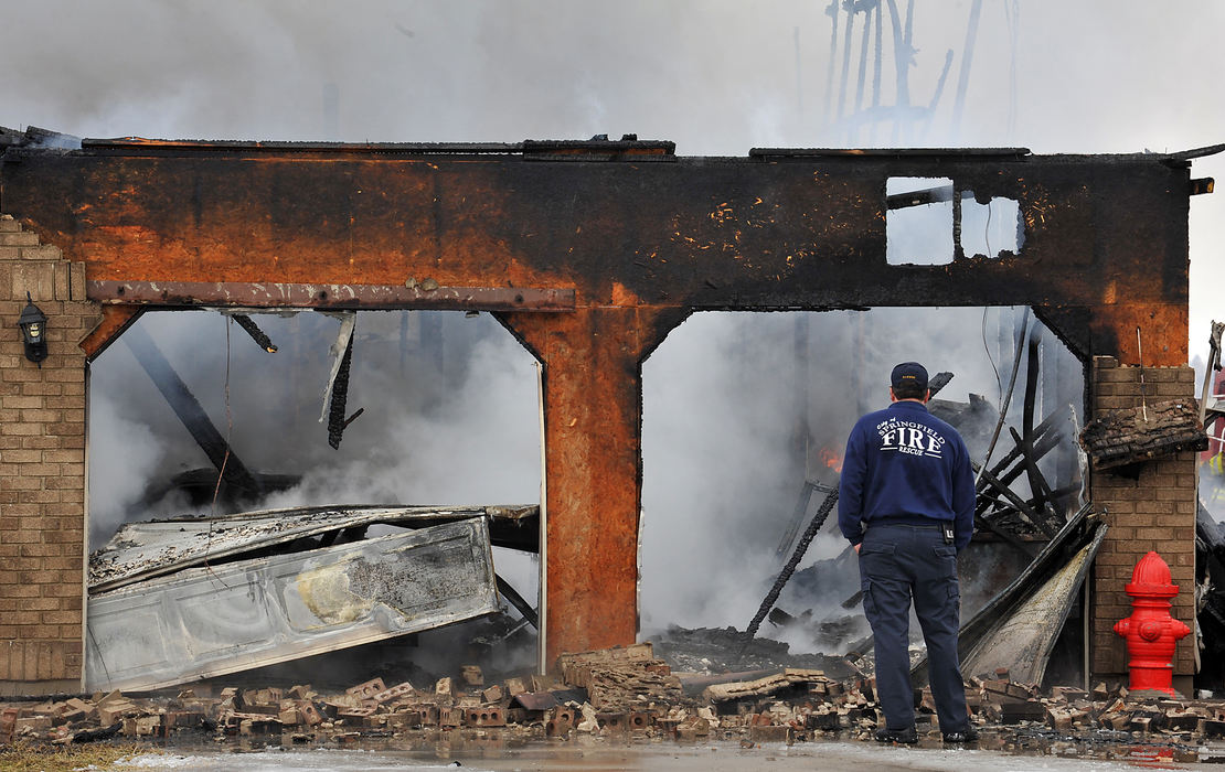 Spot News - 1st place - Springfield firefighter Ralph Harrod looks over the smoldering remains of his house. Harrod got the call that his Mad River Township house was on fire while he was at work at the Springfield Fire Division. (Bill Lackey / Springfield News-Sun)