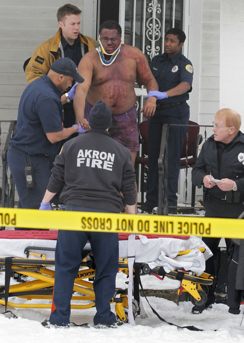 Spot News - 1st placeAkron Firefighter Paramedics help a shooting victim to a stretcher at the scene of a fatal shooting on Madison Ave. in Akron.   (Phil Masturzo / Akron Beacon Journal)