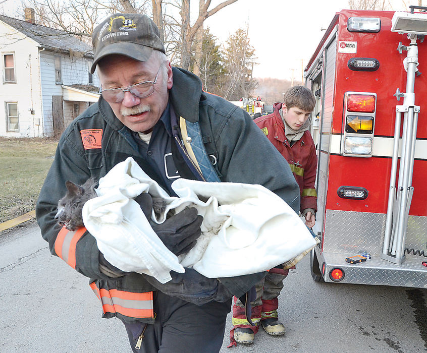 Story - 2nd placeA late afternoon fire at the Garfield Road home of Dean and Leann Fain claimed the life of the family’s dog, although firefighters were able to save the family’s cat. After helping to revive the cat, Springfield firefighter ChrisWilson carries it to a friend’s car for transport it to the Darlington, Pa., Veterinary Clinic. (Patricia Schaeffer / The (Lisbon) Morning Journal)