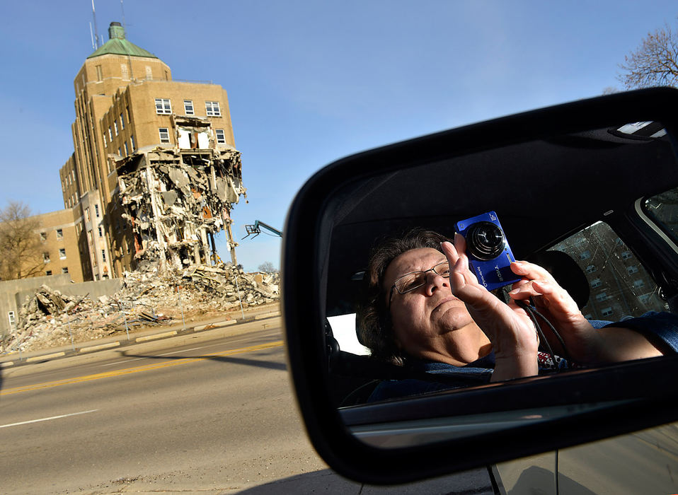 General News - 1st place - Pam Wallace, of Tremont City, is reflected in the sideview mirror of her car as she takes pictures of the Community Hospital demolition. Wallace was just one of several people who stopped by to watch as the origianal section of the Springfield landmark is demolished.  (Bill Lackey / Springfield News-Sun)