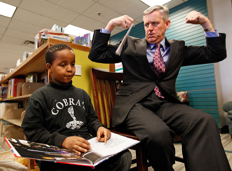 General News - 3rd place - Abdinajib Hassan, 7, of Columbus, tries to sound out a word while his reading partner, AEP vice president of corporate communications Dale Heydlauff, attempts to pantomime a clue for him as they read about about the National Basketball Association at the Columbus Metropolitan Library Hilltop Branch. The Hilltop library hosted a kick off event celebrating new reading initiatives designed to support Ohio's "Third Grade Reading Guarantee".  (Sam Greene / The Columbus Dispatch)