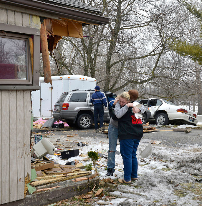 Spot News - 1st place - A resident is consoled by a friend after a car lost control and ran through her house, completely knocking off the corner of the structure in the 500 block of North Bechtle Avenue in Springfield. There were no injuries to the residents  but the driver of the car was transported to the hospital. The house suffered major structural damage. (Bill Lackey / Springfield News-Sun)