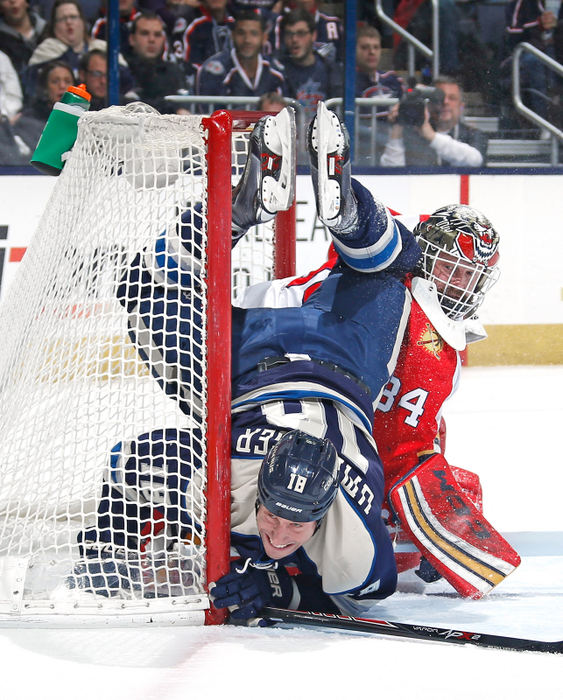 Sports - 2nd place - Columbus Blue Jackets left wing R.J. Umberger (18) is upended by Florida Panthers goalie Tim Thomas (34) after taking a shot on goal during the first period of their NHL game at Nationwide Arena in Columbus. (Sam Greene / The Columbus Dispatch)