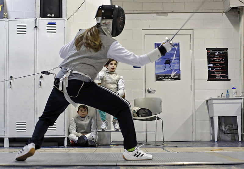 Sports Feature - 3rd place - Kaylea Dillion fences while Alex Hill and Sarah Davis watch at the Royal Arts Fencing Academy in Columbus. (Kyle Robertson / The Columbus Dispatch)