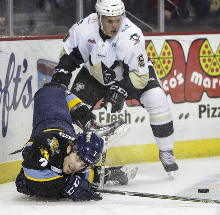 Sports - 1st place - Toledo Walleye player Tyler Barnes (7) gets twisted up making a play on the puck against Wheeling Nailers player David Makowski (9) during the first period of their hockey game at the Huntington Center.  (Andy Morrison / The (Toledo) Blade)