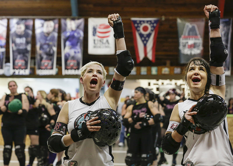    Story - 1st place - Robin Sylvester (Ophelia Burn), left, and Kerstin Kitner (Sybil Disturbance) of the Chemical Valley Rollergirls, let out a cheer after the National Anthem is played as they ready to take on the Glass City Rollers at the International Boxing Club in Oregon. (Andy Morrison / The (Toledo) Blade)