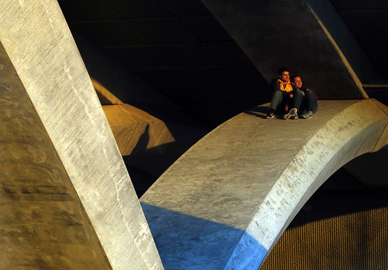 Feature - 3rd place - Kelsey Scherer an OSU student from Toledo and her boyfriend Dexter Lee who was visiting from Toledo watch the sunset on a pier underneath the Rich St. bridge in Columbus. Kelsey had been here earlier in the month and brought her boyfriend by to see the sunset from there. (Eric Albrecht / The Columbus Dispatch)