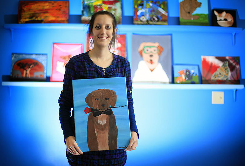 aPortrait - 1st place - Amanda Brodess shows off a recent painting at the Creative Foundations studio in Delaware.  Creative Foundations teaches and sells art from individuals with developmental disabilities.  Creative Foundations was founded to provide support to individuals with developmental disabilities.  They provide services to individuals in Champaign, Delaware, Franklin, Knox and Union counties.   (Kyle Robertson / The Columbus Dispatch)