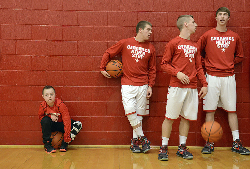 Sports Feature - HM - Slade German, 13, waits with Crooksville players Tanner German, brother; Daulton Finck and Sloan Mumford for the junior varsity game to end during a recent home game against Tri-Valley. Slade, who was born with Down syndrome, has served as the team's regular ball boy for 2 years.  (Shane Flanigan / Zanesville Times Recorder)