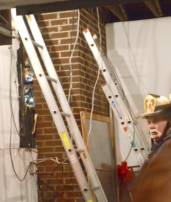 Spot News - 3rd place - While East Palestine Fire Capt. Josh Foster keeps searching for the source of the continuously smoldering material, Assistant Fire Chief Tim Griffith (right) keeps an eye on the garage area. (Patrica Schaeffer / The (Lisbon) Morning Journal)