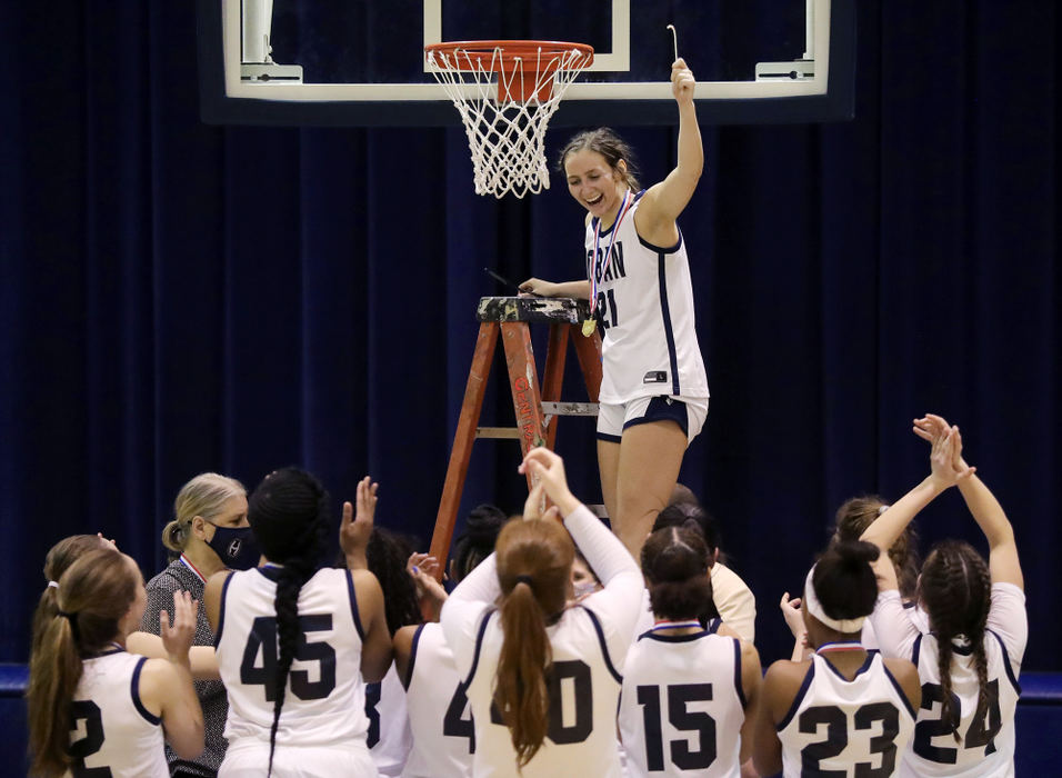 Sports Feature - HM - Teammates cheer as Hoban's Karli Anker holds up a section of the net after the Knights defeated the North Canton Hoover Lady Vikes, 65-45, in a Division I district championship game in Akron. (Jeff Lange / Akron Beacon Journal)