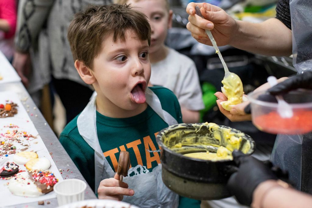 Feature - 2nd place - Nathan Shaulskiy sticks his tongue out while watching instructor Dawn Billings pour chocolate onto the dessert deviled eggs during a candy making class for 4-5 year olds at Cake Art Supplies & Bakery in Toledo. (Rebecca Benson / The Blade)