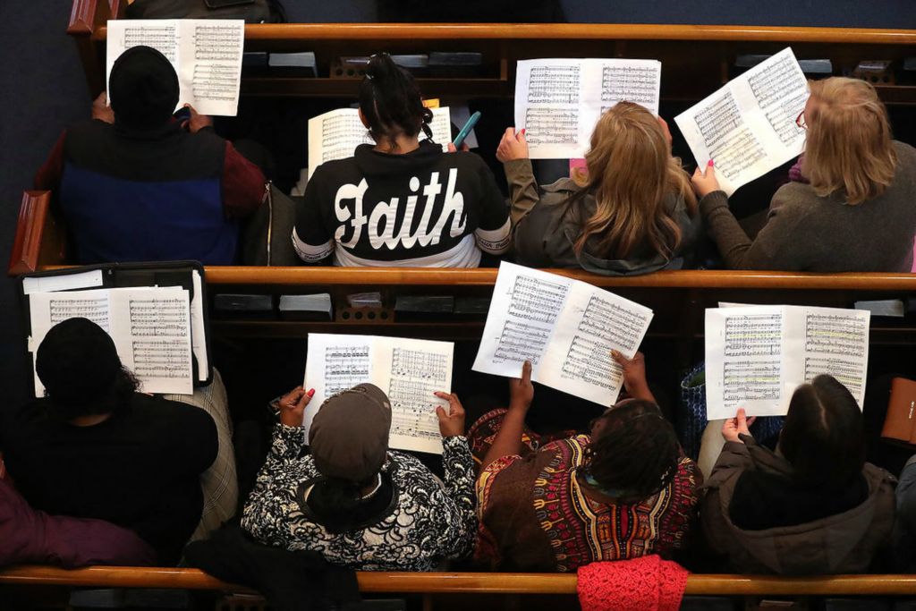 Feature - HM - Members of the tenor section look over their parts as Choirmaster Jonathan Turner works with another group during a rehearsal in preparation for the Gospel Meets Symphony choir's Feb. 8 performance at the University of Akron's E.J. Thomas Hall.   (Jeff Lange / Akron Beacon Journal)