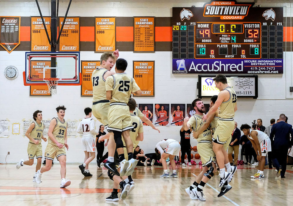 Sports Feature - HM - Perrysburg players celebrate their 52-49 victory as Southview players react to their loss in the background at the conclusion of a Northern Lakes League basketball game at Southview High School in Sylvania.  (Kurt Steiss / The Blade)