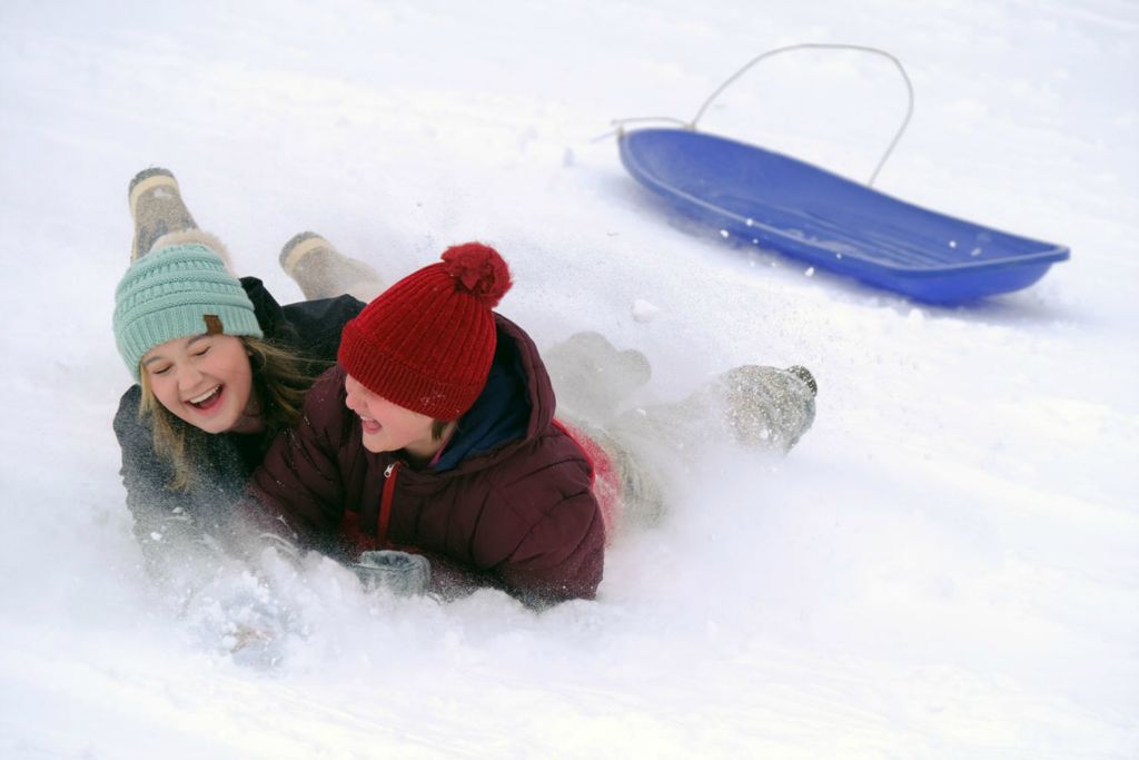 Feature - 3rd place - Avalyn Bihary (left) and Liz O'Neal share a laugh after hitting a bump and loosing their sled while going down a hill at Conneaut Haskins Park in Bowling Green.   (J.D. Pooley / Sentinel-Tribune )