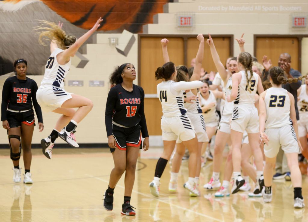 Sports Feature - 1st place - Norwalk players celebrate their 40-30 victory as Rogers’ Amare Rayford (35) and Savana Uzoigwe (15) exit the court following their regional semifinal game at Mansfield High School. (Kurt Steiss / The Blade)