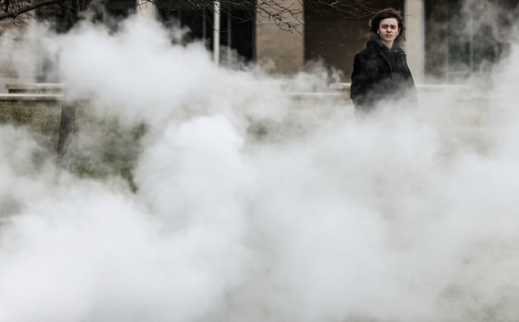 Feature - 2nd place - Aaron Hoegner, University of Toledo freshman, walks through steam and 24 degree weather past the Ottawa House West residence hall at the University of Toledo. (Jeremy Wadsworth / The Blade)