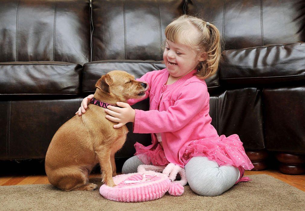 Portrait - 2nd place - Jessica Lubergerof  plays with her dog "Abby" on the floor.  She has Down Syndrome and suffers from heart disease and hearing impairment.   (Kyle Lanzer / Sun Newspapers)