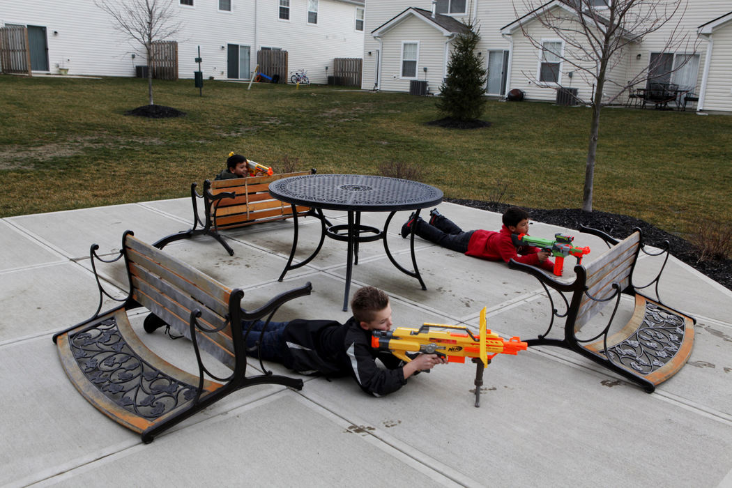 Feature - 1st placeFriends (from left) Johnathan Nhem, Charles Polan and Tyler Asbrock defend themselves against imaginary enemies . The boys who are neighbors in Reynoldsburg were duplicating moves they had watched in some of their video games. (Eric Albrecht / The Columbus Dispatch)