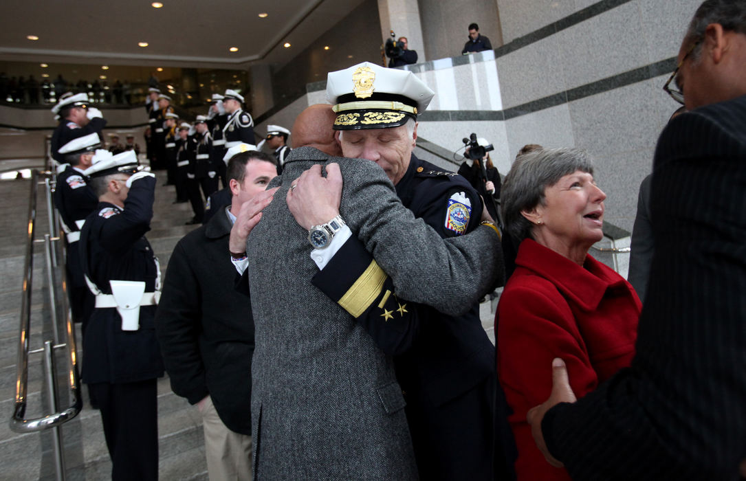 General News - 2nd placeRetiring police Chief Walter Distelzweig gets a hug from safety director Mitchell Brown as Mayor Michael Coleman (far right) talks to chief's wife Cindy  before leaving the police headquarters for the final time.  (Eric Albrecht / The Columbus Dispatch)