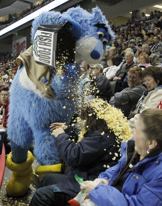 Sports feature - 3rd placeToledo Walleye mascot Cat Trick dumps a bucket of popcorn on fan Sylvia Spencer as the Walleye play Reading Royals during the third period at Huntington Center. (Andy Morrison / Toledo Blade)